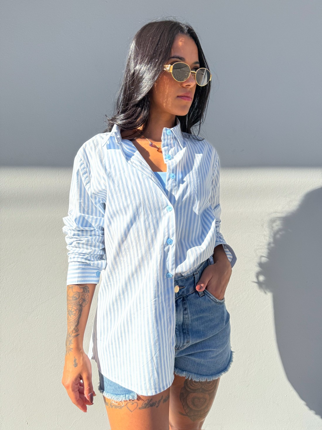 Look casual feminino – Camisa listrada azul e short jeans desfiado camisa listrada azul feminina, camisa leve verão, short jeans desfiado, moda casual feminina, look confortável, tendência feminina, camisa longa com short, outfit casual, camisa azul clara, estilo jovem feminino