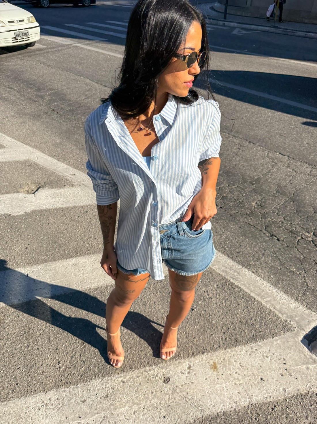 Camisa listrada azul feminina com short jeans – Street style casual camisa listrada azul, camisa feminina manga longa, camisa oversized, camisa com botões, look street feminino, short jeans desfiado, moda verão feminina, outfit casual, estilo despojado, roupas femininas modernas