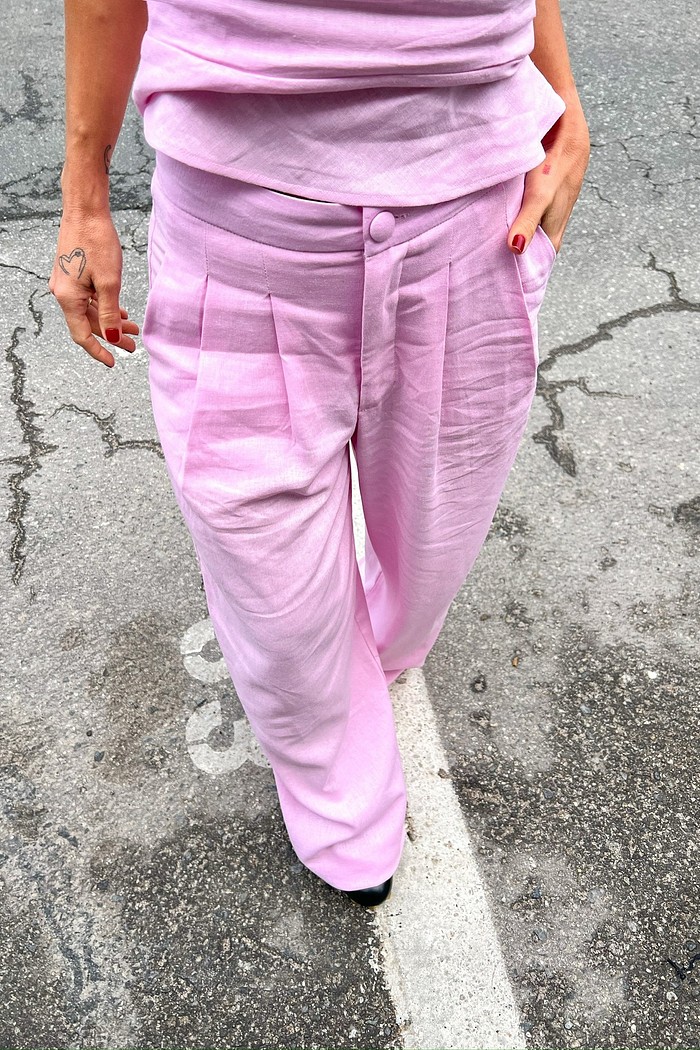 Modelo vestindo a Calça de Linho Rosa Eveline, mostrando o corte reto de alfaiataria e o caimento fluido do tecido.