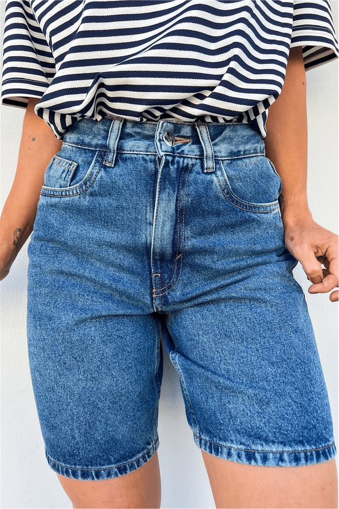 Look completo com a Bermuda Jeans Mom Lia combinada com uma blusa de listras, criando um visual clássico e elegante.