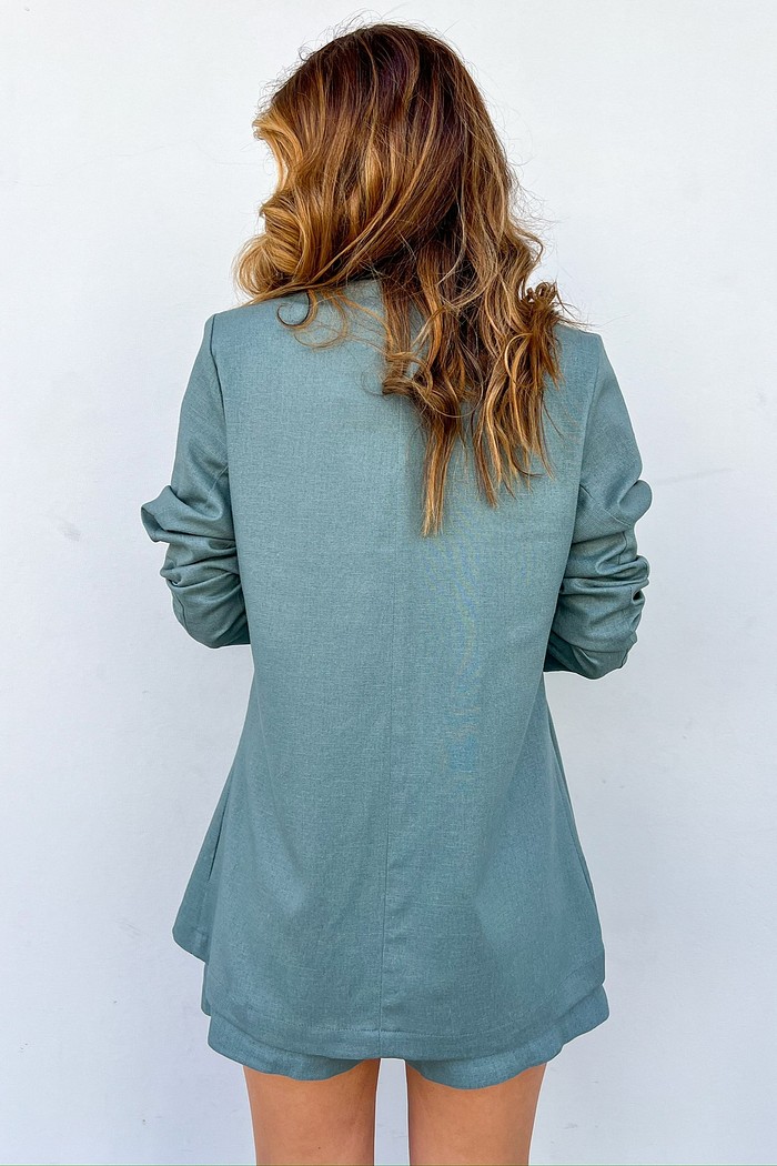 Maxi blazer verde feminino MiniMoni em linho e viscose, leve, sem forro, com ombreiras e botão frontal, ideal para trabalho e ocasiões casuais.