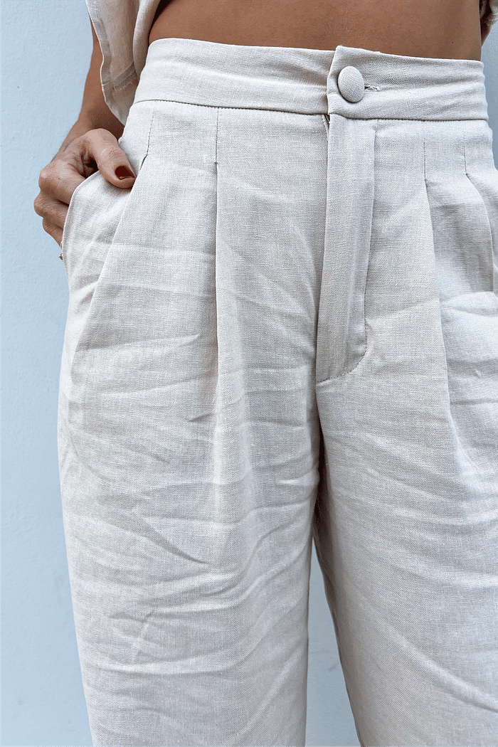 Close-up da região do cós e do bolso faca da Calça de Linho Areia Eveline, destacando o acabamento de alfaiataria.