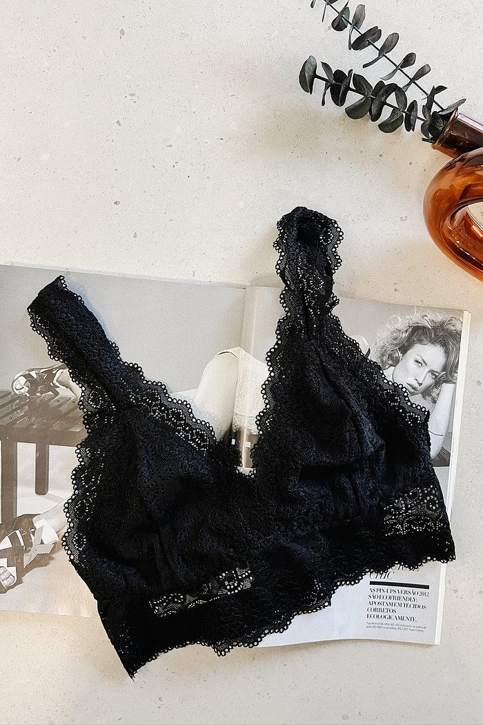 "Top de Renda Chantilly MiniMoni – cor preta Top de Renda Chantilly MiniMoni na cor preta, com design delicado em renda floral, exposto sobre revista em fundo claro.