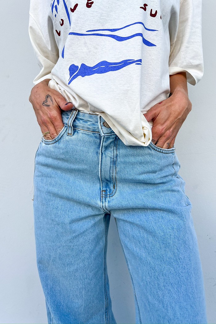 Modelo em pose descontraída usando a Calça Jeans Wide Leg Vicky, demonstrando a fluidez e o conforto do corte reto ao caminhar.