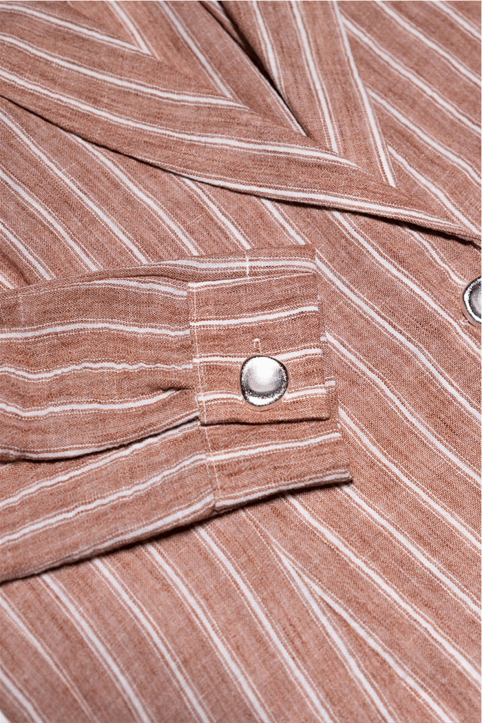 Close-up do punho do Blazer Camisa de Listras Abby, destacando o design único e o brilho do botão prateado sobre o tecido listrado.