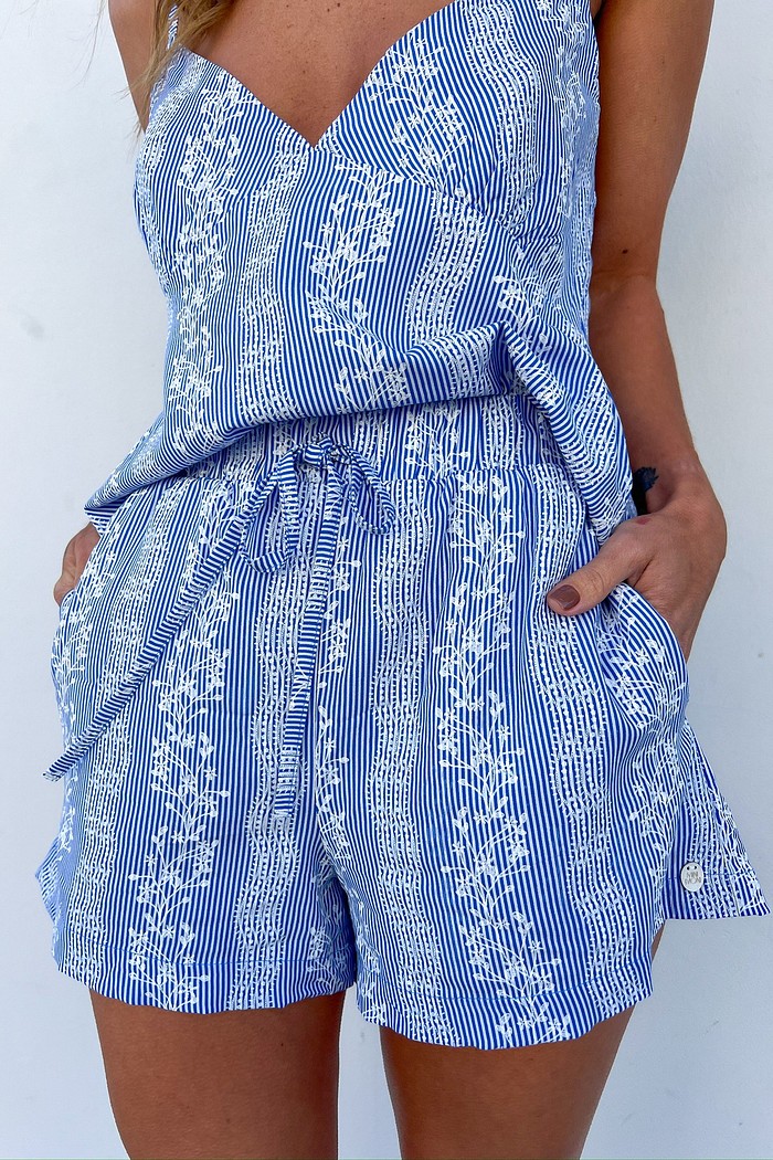 Modelo vestindo o Shorts Boxer Azul Sabine, destacando a estampa azul e branca com floral e a modelagem soltinha.